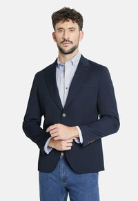 Blazer estructurado azul marino con solapas de muesca, cierre de botones y bolsillos, superpuesto a una camisa clara de rayas azules.
