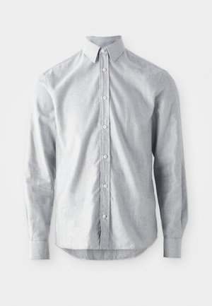 Camisa de manga larga gris claro en una tela tejida. Presenta un cierre de botones en la parte frontal, cuello puntiagudo y dobladillo redondeado. Ajuste clásico con puños abotonados.