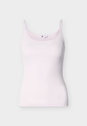 Ροζ κοντομάνικη μπλούζα με ριμπ ύφανση και λεπτές τιράντες, με διακριτικό λογότυπο Tommy Jeans στο στήθος, παρουσιάζεται σε λευκό φόντο.