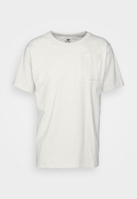 Bílý bavlněný tričko s kulatým výstřihem, krátkými rukávy a malou kapsou na levé straně s decentním logem nad ní.