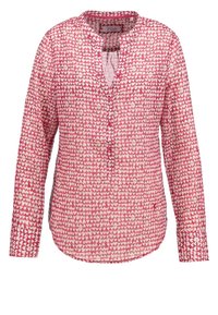 Blouse rose à manches longues avec motif de cœurs blancs, col en V avec boutons et poignets boutonnés.