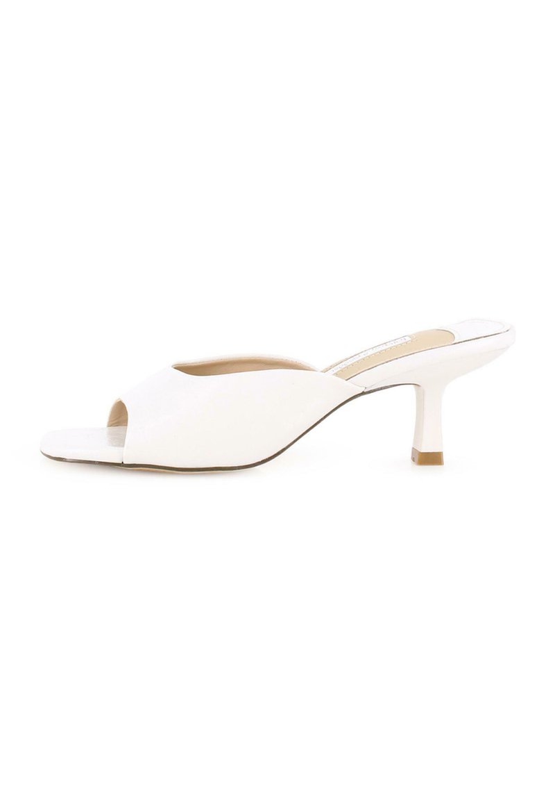 Mules de tacón abierto en blanco con un acabado suave, diseño superior curvado y un tacón de bloque de 5 cm. Costuras visibles a lo largo de los bordes.