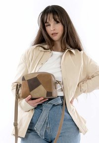 Braune und beige Umhängetasche mit geometrischem Patchwork-Design, glatter Textur und verstellbarem Tragegurt. Verfügt über metallische Beschläge und ein Logo.