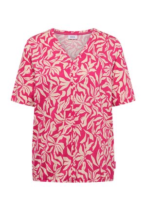 Blouse rose à manches courtes avec motif abstrait de feuilles beige, col en V et ourlet élastique, étiquette "Cecil" à l'intérieur du col.
