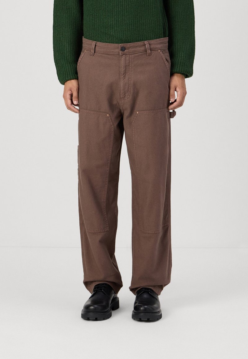 Brown cargo pants with a relaxed fit, featuring dual front pockets, stitching accents, and a waistband with a button closure.