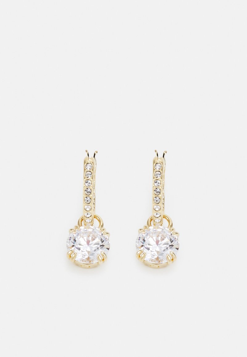 Paire de boucles d'oreilles pendantes dorées avec des rangées verticales de petits cristaux et de grands pendentifs ronds en pierres précieuses claires.