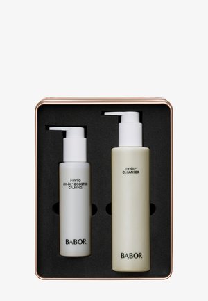 Babor Hautpflege-Set in einer roségoldenen Dose. Enthält einen beruhigenden Booster in einer mattweißen Flasche und einen Reiniger in einer hellgrünen Flasche.