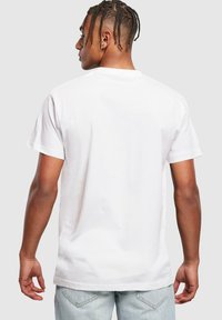 Witte katoenen t-shirt met korte mouwen, ronde hals en een losse pasvorm. Eenvoudig ontwerp met een gladde textuur en geen zichtbare patronen of accenten.