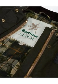 Groene en bruine jas met een bloemrijke voering aan de binnenkant; heeft goudkleurige hardware, gestructureerde stof en een label met de tekst "Barbour ERDEM."