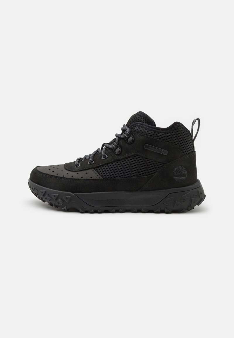 Scarpe da trekking nere alte fino alla caviglia, realizzate in materiali scamosciati e in rete, con una suola in gomma testurizzata, design con lacci e un occhiello sul retro.
