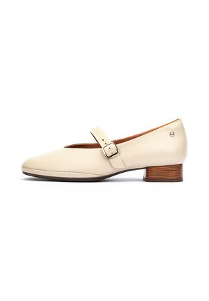 Zapato Mary Jane de color crema con correa de hebilla cuadrada, tacón bajo de bloque de madera y acabado de cuero liso visto desde un lado.