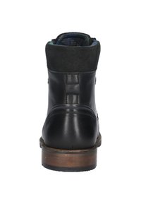 Botín negro de cuero con parte superior de ante, tacón de madera y forro azul con diseño. Presenta costuras mínimas y un diseño elegante.