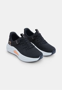 Baskets de sport noires avec une tige en mesh respirant, semelle intermédiaire blanche et accents orange. Elles disposent de lacets plats et d'un embout renforcé.