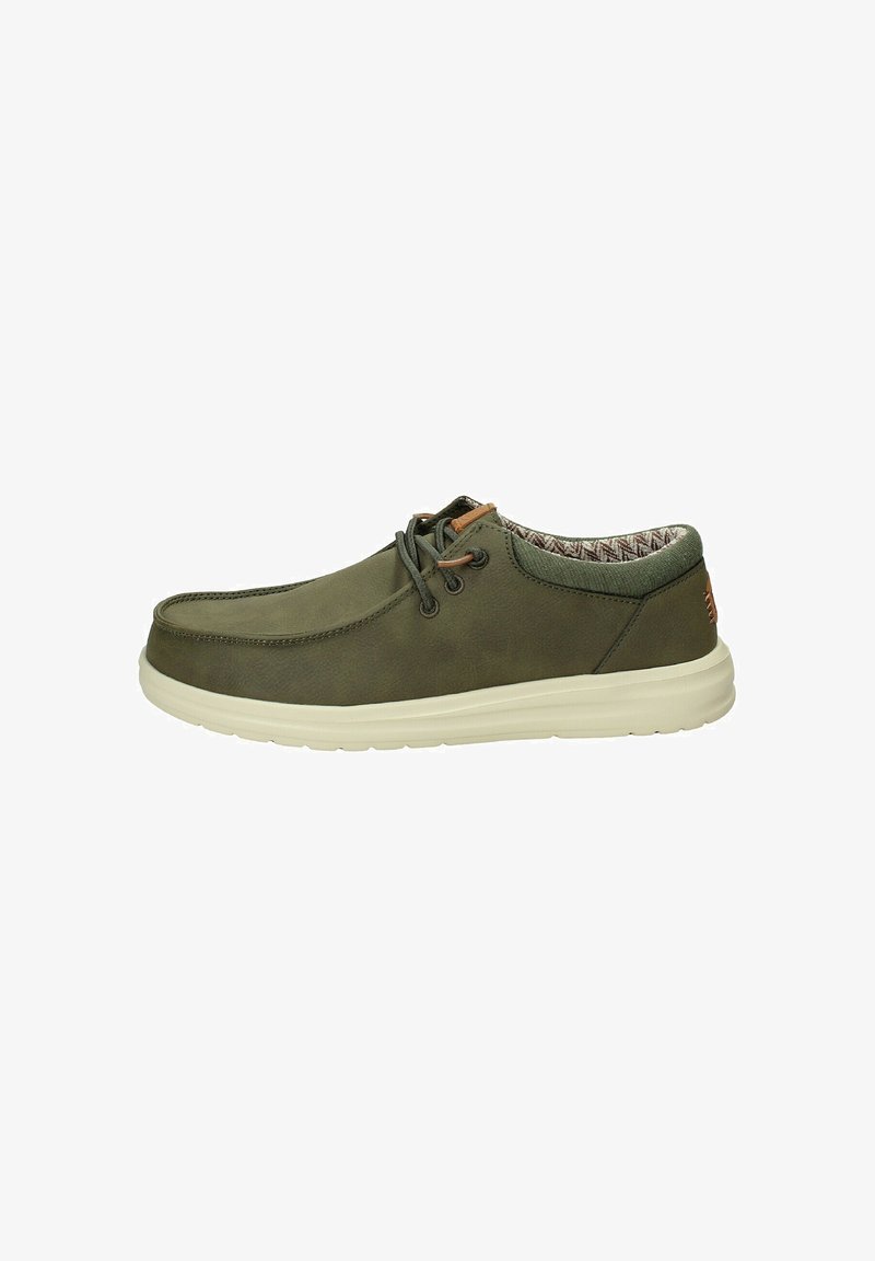 Grüne Freizeitschuhe mit einer weichen, strukturierten Oberfläche, runder Spitze und weißer Gummisohle. Mit braunen Lederakzenten und gemusterter Innenauskleidung.