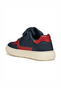 Sneaker bassa navy e rossa in pelle con suola testurizzata, dotata di una strap con chiusura a velcro e collo imbottito per il massimo comfort.