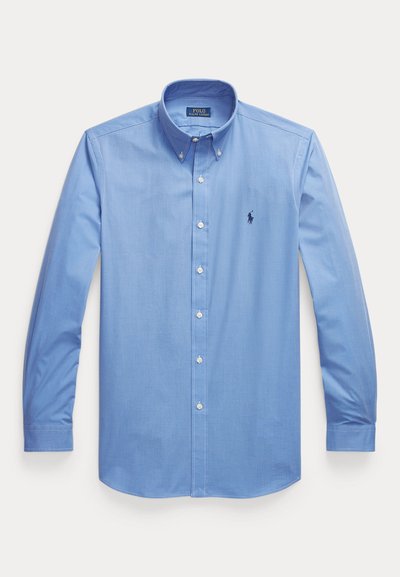 Cămașă cu mâneci lungi, de culoare albastru deschis, cu nasturi, guler cu nasturi și un mic logo brodat cu un cal albastru închis pe partea stângă a pieptului.