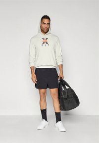 Light grey hoodie with logo, black shorts, white sneakers, and black gym bag. Simple design, cotton material, casual fit, and contrasting colors.