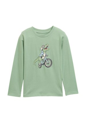 Langärmliges, hellgrünes Baumwoll-T-Shirt mit einem Grafikmotiv eines Dinosauriers, der ein Fahrrad fährt, Kopfhörer trägt und eine blaue Jacke anhat.