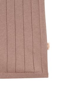 Gros plan sur un tissu maille côtelée mauve avec des rayures verticales et une petite étiquette en tissu beige sur le côté droit.