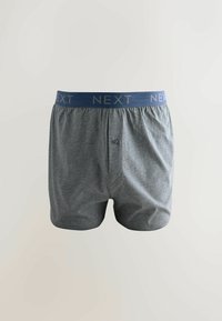 Sivé boxerky z jemnej látky, s modrým pásom s nápisom "NEXT" zlatými písmenami a zapínaním na gombík vpredu.