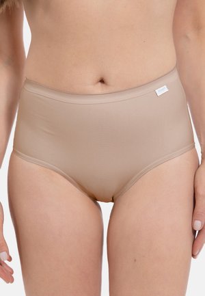 Donna che indossa biancheria intima beige a vita alta senza cuciture con una piccola etichetta bianca sull'anca sinistra, su sfondo bianco.