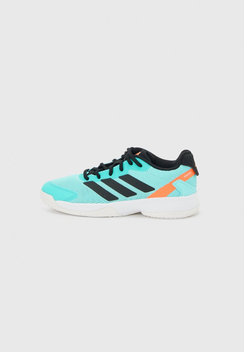 Chaussure de sport turquoise avec des lacets noirs, des bandes noires sur le côté, un accent orange près du talon et une semelle blanche sur un fond clair uni.