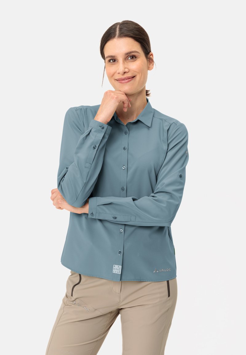 Chemise à manches longues bleu clair, fabriquée dans un tissu doux, dotée d'un col pointu et d'un logo discret à l'ourlet.