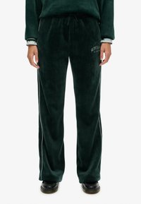 Grønne, bløde stofsweatpants med en afslappet pasform, der har sidelister og et logodetalje på venstre lår. Snoretræk i taljen.