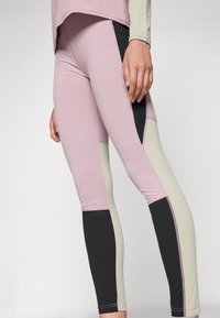 Rózsaszín, fekete és világoszöld színblokk mintával díszített leggings. Rugalmas anyagból készültek, sima felületük és testhezálló szabásuk van.