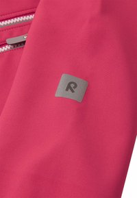 Tissu rose avec une texture lisse présentant un logo rectangulaire argenté détaillant la lettre "R". Comprend une poche zippée avec des surpiqûres contrastantes.