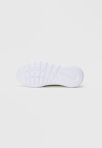 Suola di sneaker in gomma bianca con un motivo di grip testurizzato e un piccolo dettaglio del logo. Superficie liscia con accenti in rilievo per la trazione.