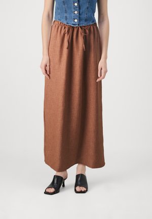 Brun, knelengde skjørt med teksturert stoff, elastisk liv, og sidespalter, parret med svarte åpne tå-sko.