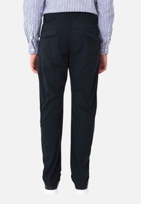 Pantaloni neri in cotone, con taglio dritto, vita elasticizzata e due tasche posteriori con pattina. Rifiniti con chiusura a bottone.
