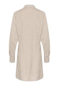 Robe chemise beige en tissu doux. Présente un col, des manches longues avec des poignets boutonnés, et un dos ajusté avec des plis.