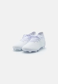 Scarpe da calcio bianche con tomaia testurizzata, dotate di lacci tonali, profilo basso e suola in gomma con tacchetti per una migliore aderenza.