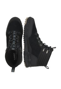 Czarne buty trekkingowe z połączeniem zamszu i materiałów syntetycznych. Posiadają wzmocniony nos, teksturowane czarne boki oraz podeszwę z białymi plamkami.
