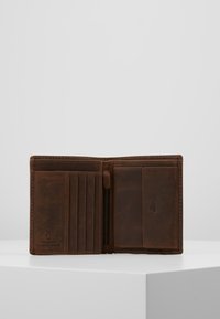 Hnědá kožená peněženka, otevřený pohled, s několika přihrádky na karty, zipovou kapsou a hladkým povrchem. Minimalistický design.