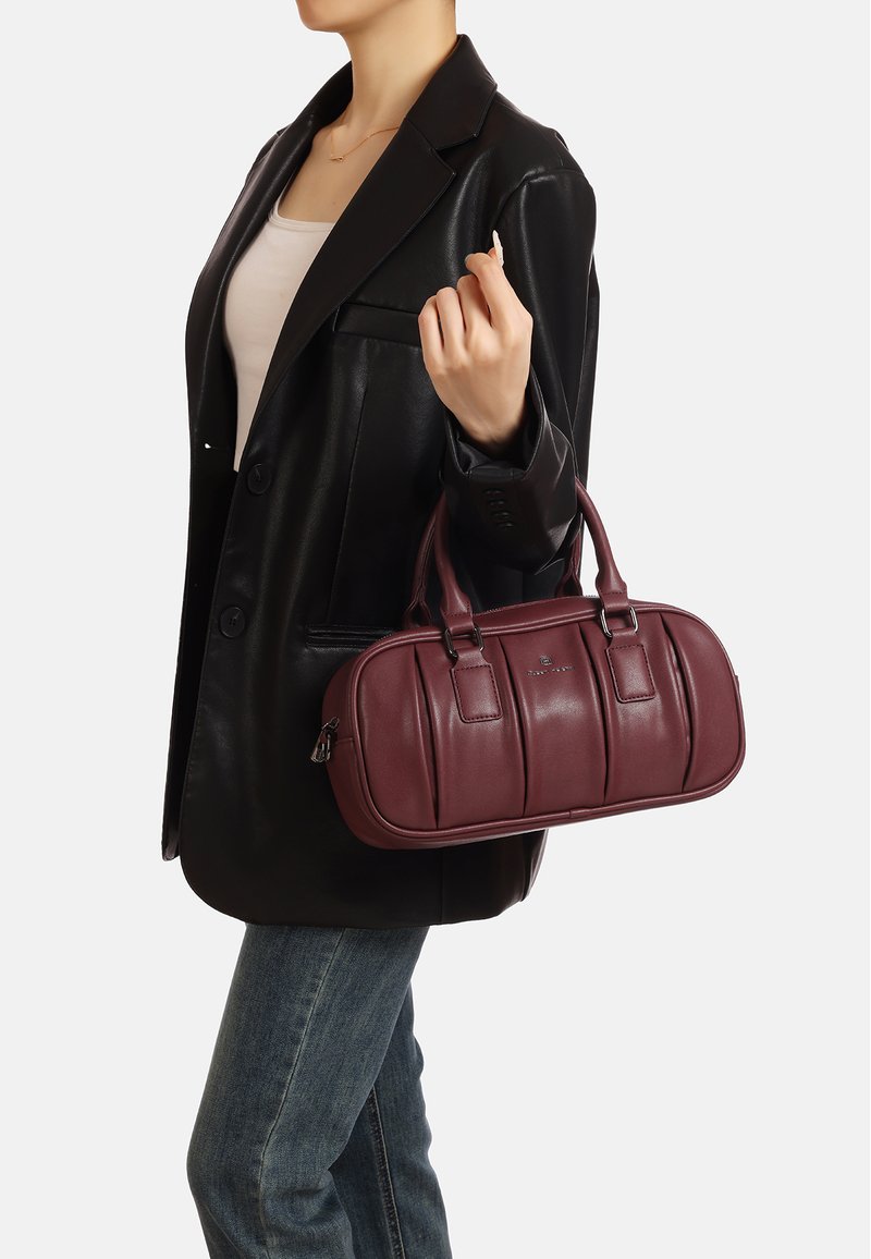 Borsa in pelle borgogna con una texture liscia, caratterizzata da due manici superiori, una chiusura con zip e dettagli a pannello verticali.