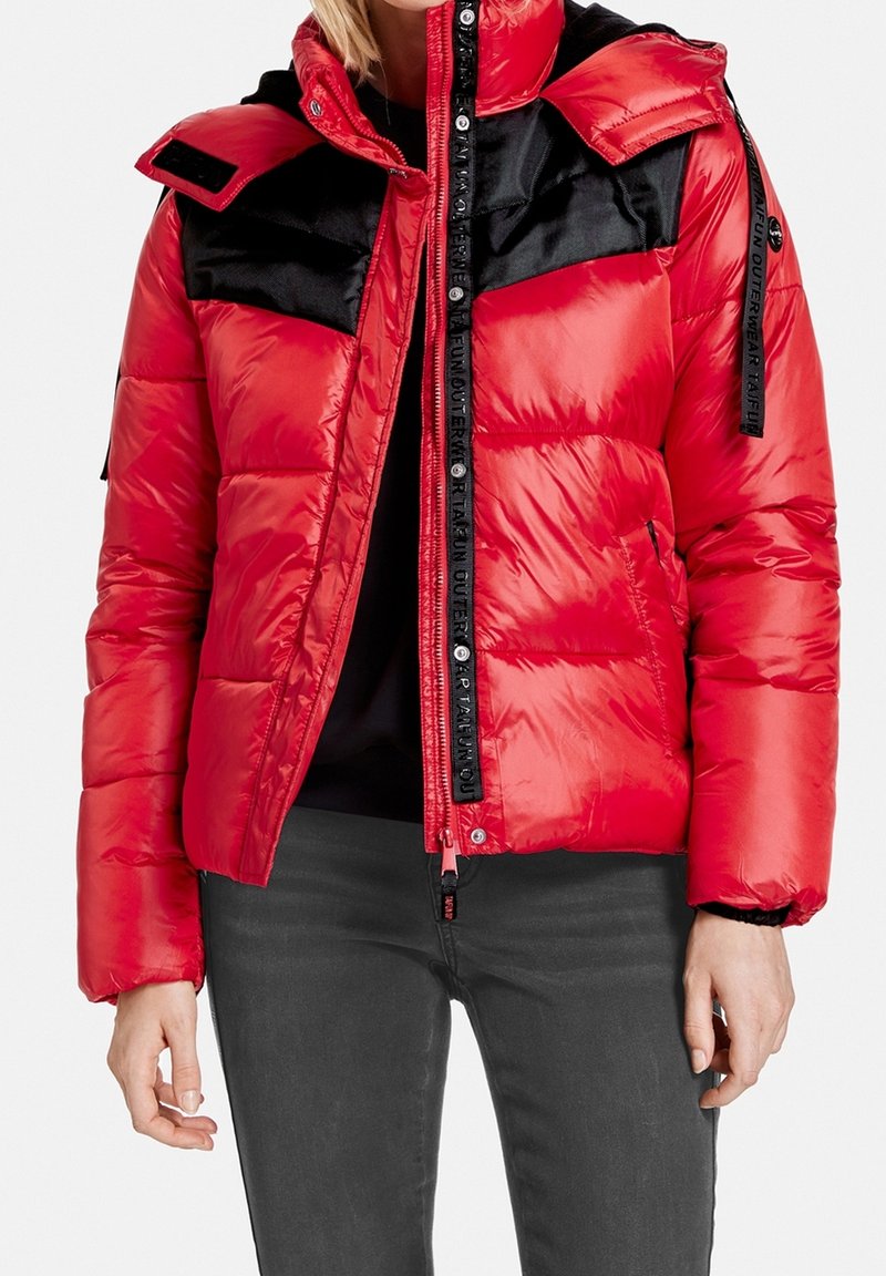 Czerwona kurtka puchowa z czarnymi wstawkami, błyszcząca tkanina, zamek błyskawiczny, regulowany kaptur oraz paski z logo na ramionach.