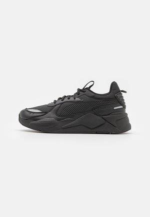 Sneaker atletiche nere che presentano un mix di materiali lisci e texturizzati, un collare imbottito e una robusta suola in gomma con accenti geometrici.