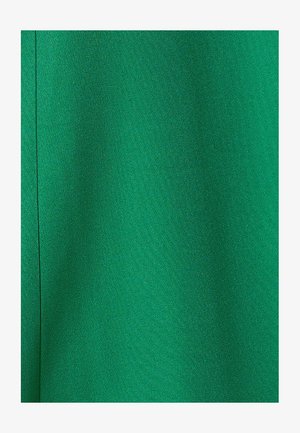 Tissu vert avec une texture lisse et un éclat subtil, présentant une couleur unie sans motifs ni accents décoratifs.