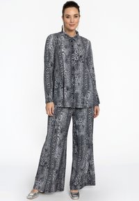 Ensemble deux pièces comprenant une chemise à manches longues et un pantalon large au motif serpent noir et gris, confectionné dans un tissu doux.