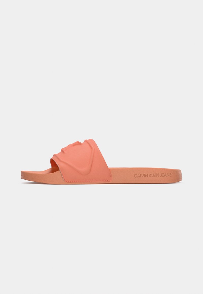 Chancla de Calvin Klein en color coral rosa, con un diseño de tira moldeada, material de goma suave, suela plana y un acento de marca en el lateral.