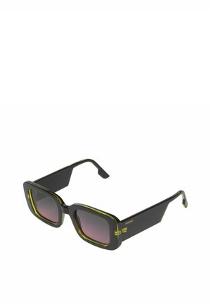 Lunettes de soleil noires avec des montures carrées audacieuses et des accents jaunes. Les verres dégradés passent de sombre à clair. Matériau en plastique lisse.