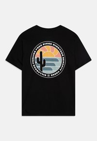 Czarny bawełniany t-shirt z okrągłą grafiką przedstawiającą kaktusa, zachód słońca i fale w pastelowych kolorach. Tekst otacza ten wzór.