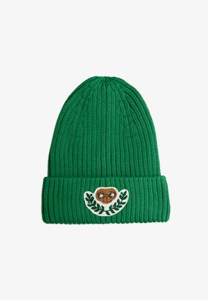 Zelená pletená čepice s žebrovanou texturou, na přední straně s krémovou nášivkou a designem hnědé tváře a listu.