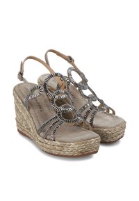 Sandalias de cuña con parte superior de tejido beige, acentos metálicos circulares y suela de yute trenzado. Las correas son ajustables con una hebilla. Plantilla suave.