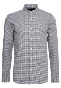 Camicia a maniche lunghe a scacchi nera e bianca, con colletto button-down e bottoni frontali bianchi.