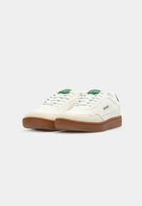 Weiße Sneakers mit grünen Akzenten, aus Leder und Wildleder, im Low-Top-Design, mit strukturiertem cremefarbenem Zehenkappeneinsatz und brauner Gummisohle.