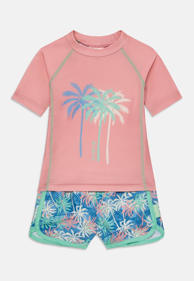 Camisa de proteção rosa de mangas curtas com gráfico de palmeira, combinada com calções azuis com padrões de folhas tropicais e acabamentos verdes.